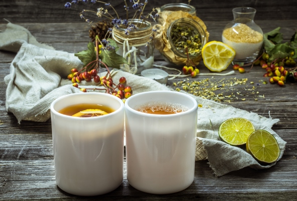 two cups of tea on a beautiful wooden background with lemon and herbs winter autumn - Цитрусовый чай с имбирём и карамболой