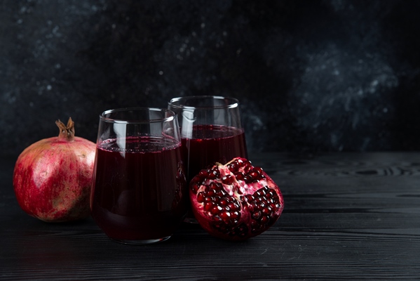 two glass cups of sweet pomegranate juice on dark - Гранатовый напиток