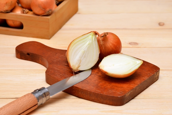 white onion cut on a cutting board on the table - Салат овощной с сыром тофу