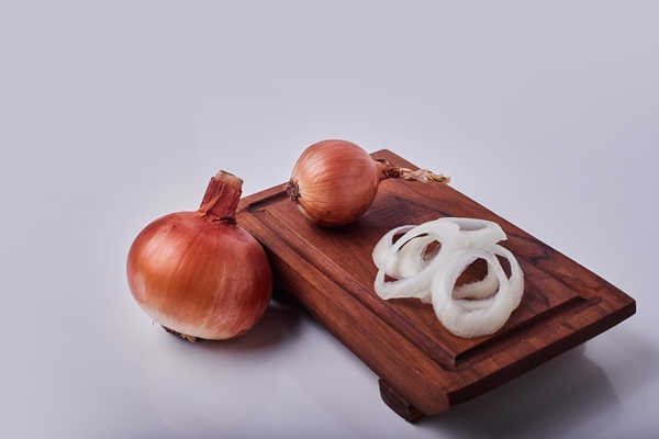 whole and sliced onions on a wooden board 1 - Малосольная селёдка домашняя с луком