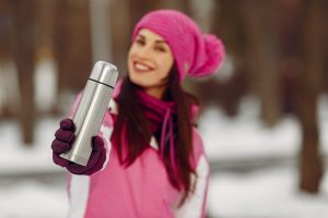 woman in a winter park lady in pink sportsuit girl with a thermos - Имбирный напиток с чесноком