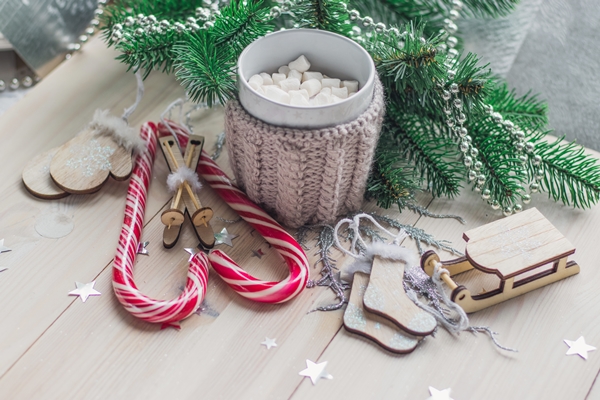 wooden table covered in candy canes marshmallows and christmas decorations under the lights - Новогодний бутерброд "Снеговик"