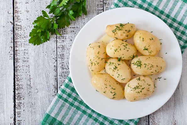 young boiled potatoes with butter and dill on a white plate - Постный салат из грибов с картофелем