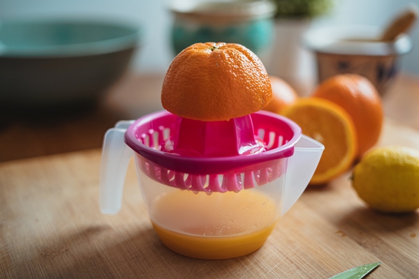 an orange on a squeezer before being squeezed to make orange juice - Безалкогольный апельсиновый глинтвейн с имбирём