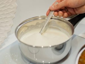 bechamel sauce onn induction stove cook stirs with spoon we stay at home and cook lasagnin the kitchen - Ванильный соус