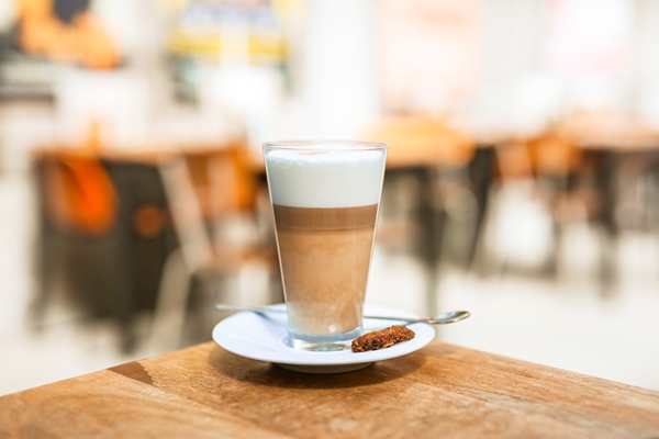 cappuccino coffee glass with spoon on wooden table - Латте макиато