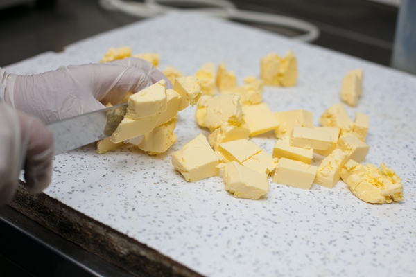chef cutting unsalted butter into pieces - Правила приготовления супов-пюре