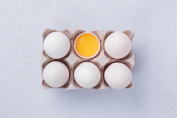 chicken eggs in paper container on white surface - Бульон с рисовым пудингом