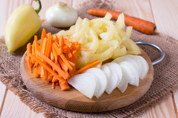 chopped onions carrots and bell peppers on cutting board - Щи с головизной