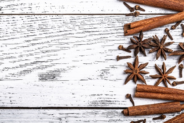 cinnamon sticks anise stars and cloves whole indian spices on white wooden background - Яблочный глинтвейн с изюмом и лимоном