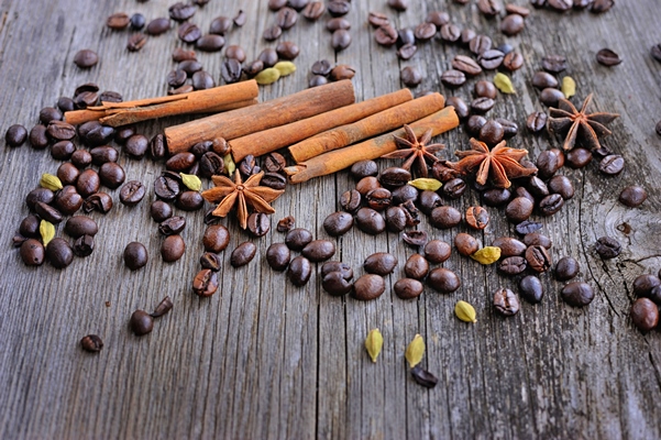 closeup of cinnamon anise and coffee beans on a rustic wooden background with copy space - Кофе с кардамоном и сахаром