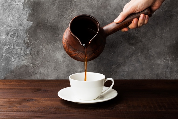 coffee in white cup and clay cezve on wooden background - Кофе с лимоном