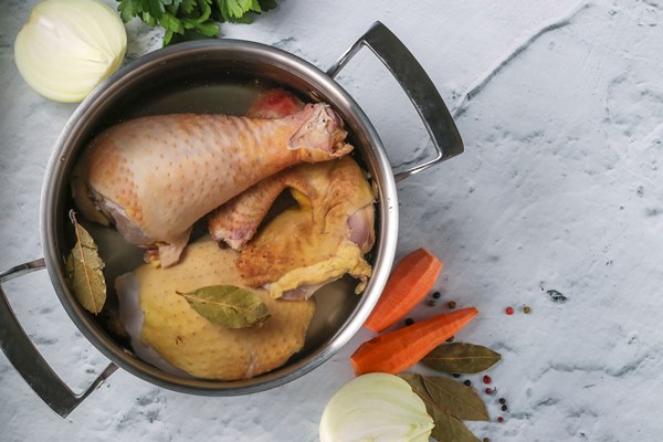 cooking broth from homemade chicken with pepper and bay leaf in a pan on a marble background - Правила приготовления супов-пюре