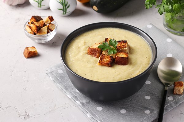 creamy chicken and zucchini thick soup served with white bread croutons in dark bowl on gray background close up - Правила приготовления супов-пюре