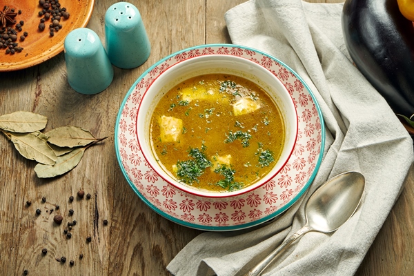 fish soup in a red bowl on a wooden table healthy seafood soup restaurant serving ukha - Щи с головизной