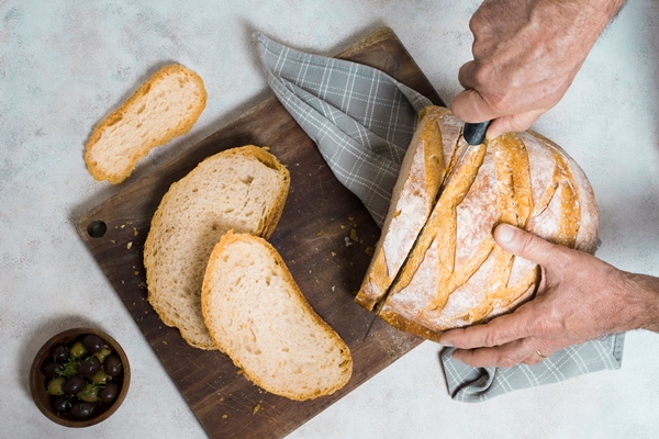 flat lay person cutting slices of bread - Французские тосты с яйцом