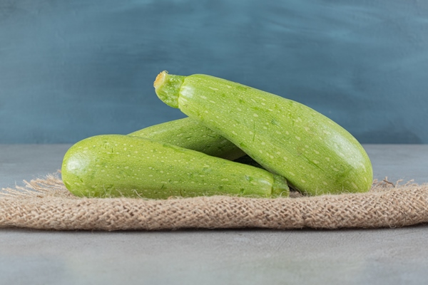 four fresh zucchini vegetables on a sackcloth high quality photo - Кабачковые оладьи