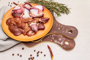 fresh raw duck offal heart liver stomach dry spices salt chili pepper wooden cutting boards - Рассольник