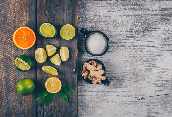 green and yellow lemons and orange with cups of salt and ginger top view on a wooden tray and gray wooden background - Безалкогольный глинтвейн с клюквой