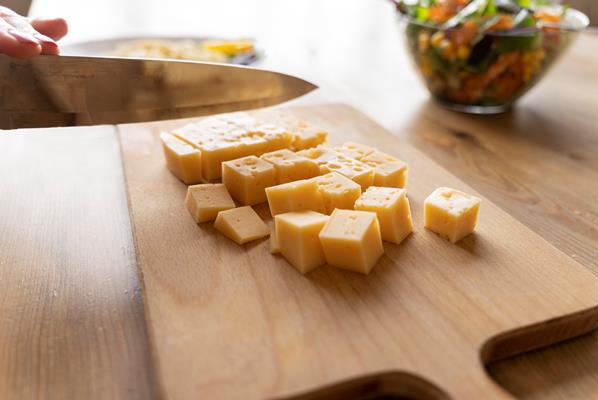knife cutting cheese on wooden board - Яйца "Орсини"