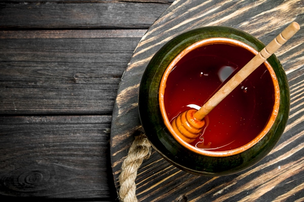 natural honey in the pot on a wooden table - Яблочный глинтвейн с изюмом и лимоном