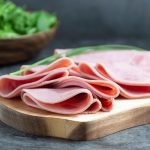 pork ham slices on cutting board over dark background - Фриттата с макаронами, сыром и ветчиной