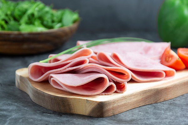 pork ham slices on cutting board over dark background - Фриттата с макаронами, сыром и ветчиной