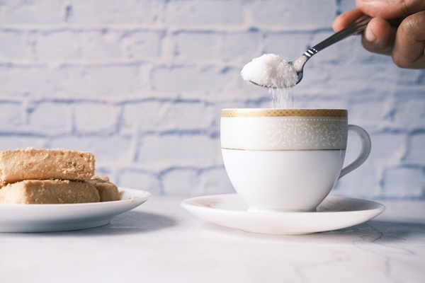 pouring white sugar in a tea cup - Кофе по-венски