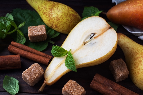 ripe juicy yellow pears with cinnamon on wooden background conference pears for caramelization - Безалкогольный глинтвейн из груш