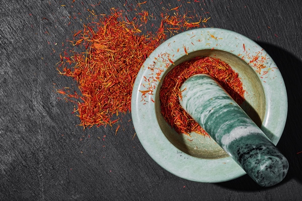 saffron in a marble mortar on a dark stone background top view seasoning preparation aromatic spices and seasonings - Чихиртма