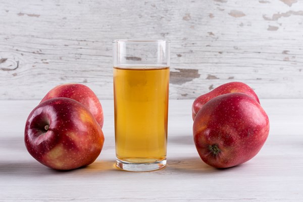 side view apple juice with red apples on white wooden table - Безалкогольный глинтвейн на чае и соке