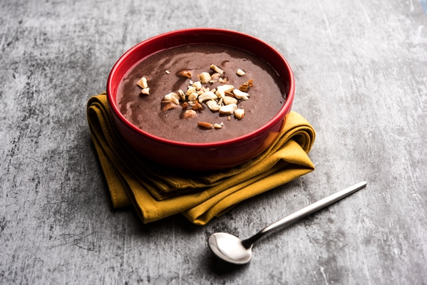 sweet ragi malt or healthy ragi porridge in a bowl garnished with crushed dry fruits - Русская кулага (солодуха)