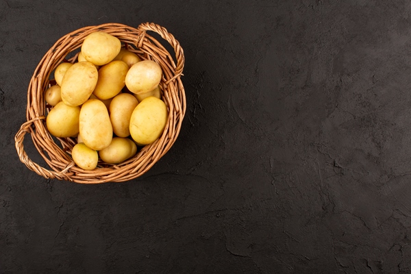 top view potatoes in basket on the dark floor - Драники с луком, сыром и чесноком