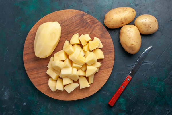 top view sliced fresh potatoes vegetables dark blue background - Суп из брюссельской капусты со сметаной и сливочным маслом