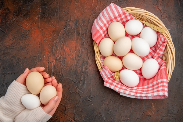 top view white chicken eggs inside basket with towel on a dark table - Омлет со шпинатом