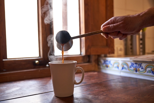 unrecognizable person pouring coffee into mug - Американо