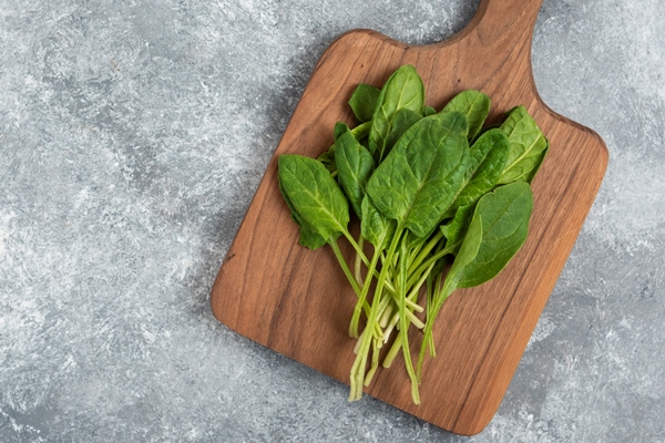 wooden board of fresh healthy green leaves on marble - Щавелевый суп