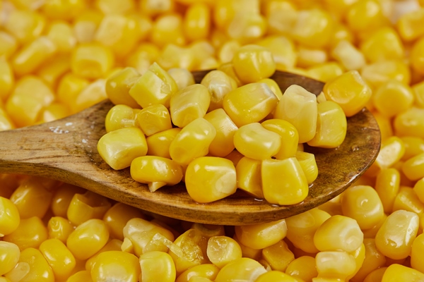 a heap of boiled sweet corn with a wooden spoon on a white table - Куриный суп с кукурузой и сыром