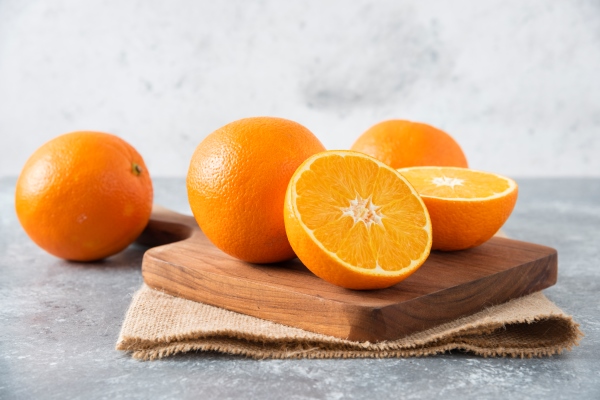 a wooden board full of juicy slices of orange fruit on stone table - Апельсиновый соус