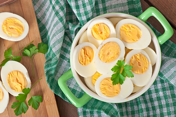boiled eggs in a bowl decorated with parsley leaves - Салат из крабовых палочек с рисом