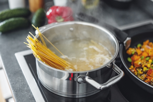 boiling pot with cooking spaghetti pasta in the kitchen closeup - Лапшевник с мясом