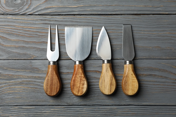 cheese knives on wooden background top view and space for - Правила подачи сыров