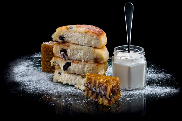 cheese pancakes with a raisins on a black background - Сырники из творога с картофелем