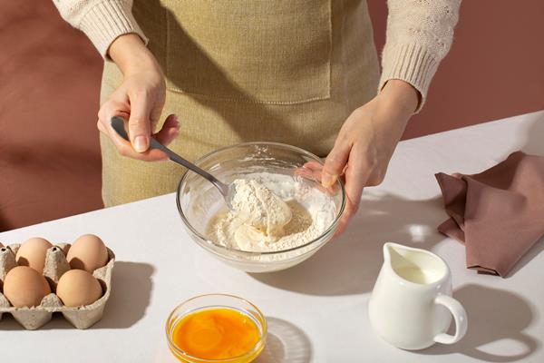 close up hands holding spoon and bowl - Клёцки из брынзы