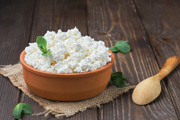 farmer s cottage cheese in a traditional clay bowl next to a wooden spoon a black wooden table 1 - Картофельные котлеты с творогом