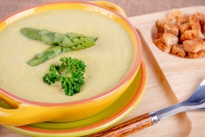 fresh asparagus creamy soup and ingredients on wooden table selective focus - Суп-пюре из спаржи на молоке