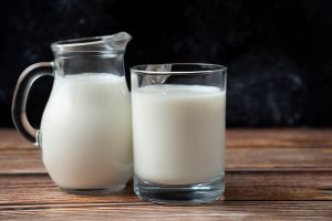 fresh milk in a mug and jug on wooden table - Сырный суп с копчёностями и молоком