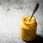 fresh mustard in a jar with a spoon on stone table - Сырный суп с копчёностями и молоком