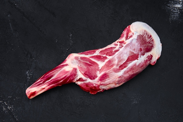 fresh raw lamb leg bone in on wooden cutting board with herbs and seasoning - Правила выбора и приготовления мяса