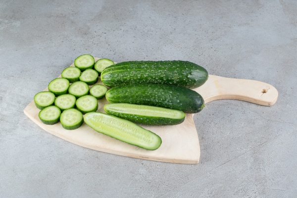 fresh sliced cucumbers with knife on a wooden board high quality photo - Картофельный салат с огурцами и яйцом